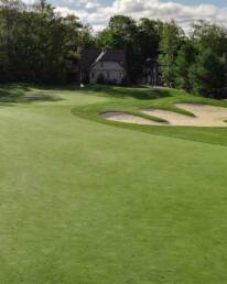 Muskoka golf green with bunker and home